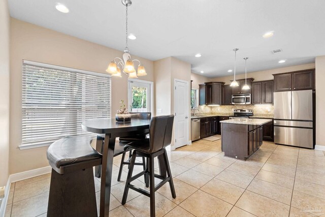 1824 Lindsey Magnolia Ct, Navarre, FL 32566 - kitchen with stainless steel appliances, dark brown cabinetry, a sink, backsplash, and a chandelier