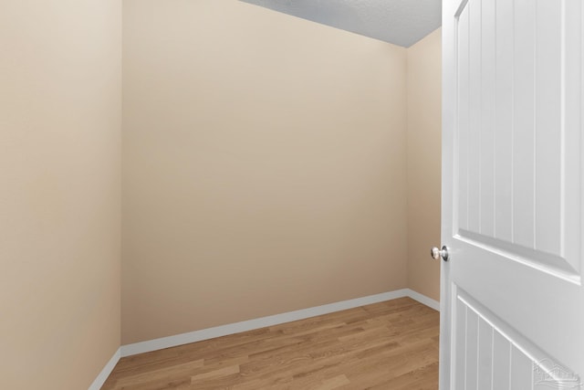 1824 Lindsey Magnolia Ct, Navarre, FL 32566 - unfurnished room with light wood-style floors, baseboards, and a textured ceiling