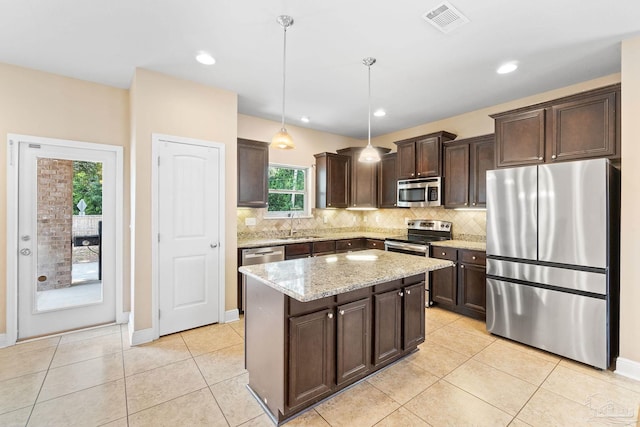 1824 Lindsey Magnolia Ct, Navarre, FL 32566 - kitchen featuring stainless steel appliances, dark brown cabinets, backsplash, a sink, and a center island