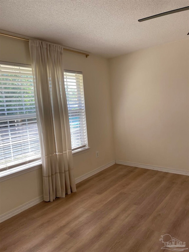 empty room featuring wood-type flooring and a textured ceiling