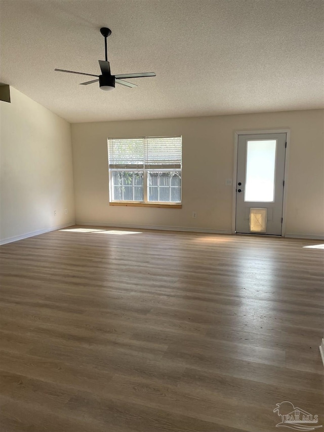 spare room featuring ceiling fan, a wealth of natural light, and dark hardwood / wood-style flooring