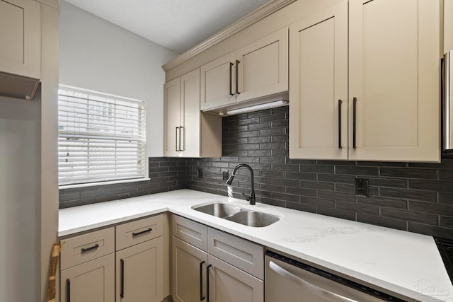 kitchen featuring sink, stainless steel dishwasher, backsplash, a textured ceiling, and cream cabinetry