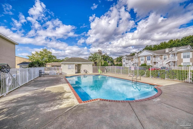 view of pool featuring an outbuilding and a patio