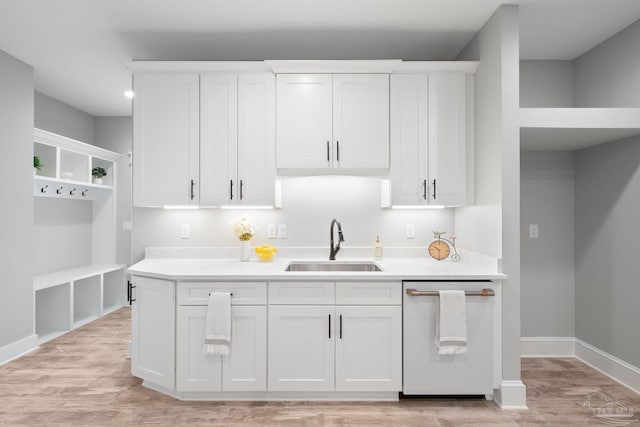 kitchen with light hardwood / wood-style floors, white cabinetry, stainless steel dishwasher, and sink