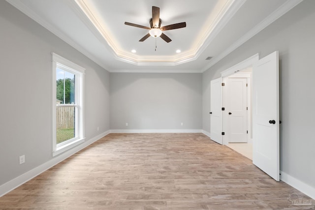 interior space featuring ceiling fan, ornamental molding, a tray ceiling, and light hardwood / wood-style floors