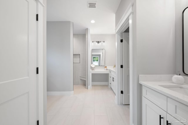 bathroom featuring vanity, a tub to relax in, and a baseboard heating unit