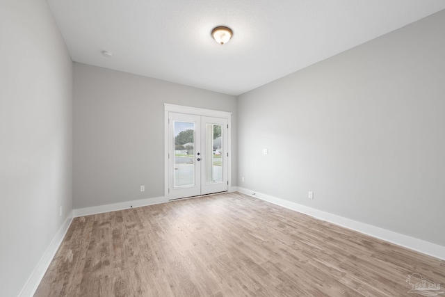 unfurnished room featuring french doors and light hardwood / wood-style floors