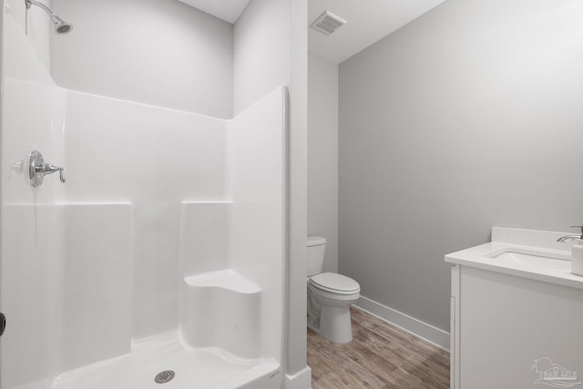 bathroom featuring vanity, toilet, a shower, and wood-type flooring