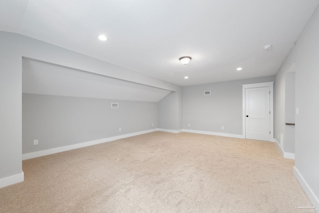 carpeted empty room with lofted ceiling