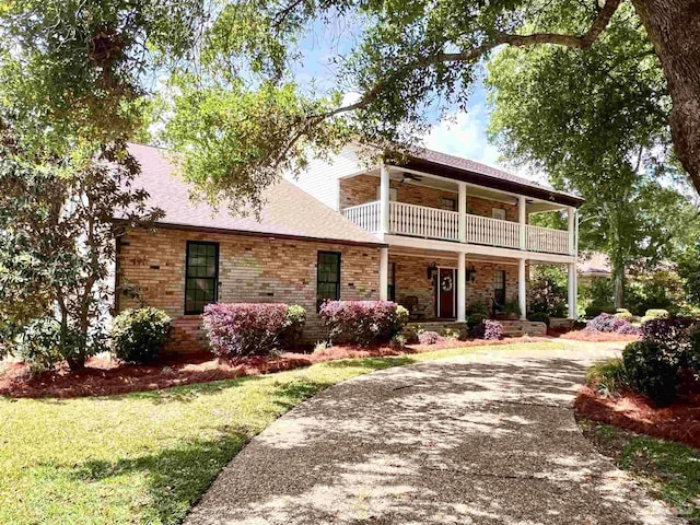 39 Blithewood Dr, Pensacola, FL 32514 - view of front facade featuring a balcony, covered porch, curved driveway, a front yard, and brick siding