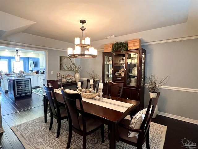 39 Blithewood Dr, Pensacola, FL 32514 - dining area with beverage cooler, a chandelier, dark wood finished floors, baseboards, and bar area