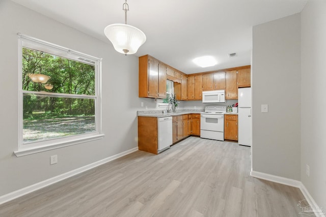 6257 Mohawk Trl, Milton, FL 32583 - kitchen with white appliances, light countertops, light wood-type flooring, and brown cabinets