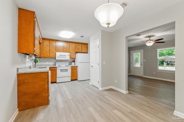 6257 Mohawk Trl, Milton, FL 32583 - kitchen featuring white appliances, brown cabinets, light wood-style floors, light countertops, and baseboards