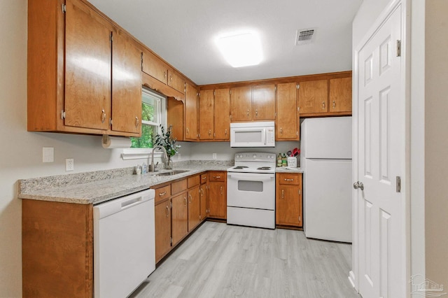 6257 Mohawk Trl, Milton, FL 32583 - kitchen featuring white appliances, a sink, light wood-style flooring, and brown cabinetry
