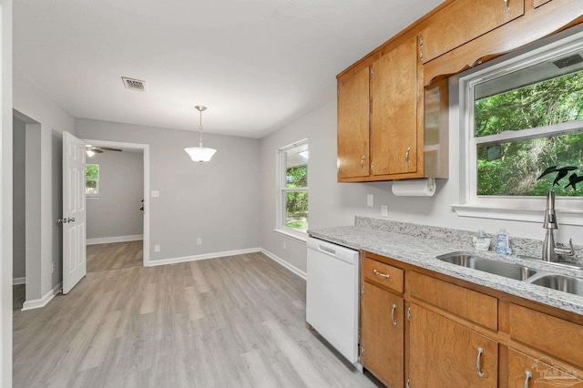 6257 Mohawk Trl, Milton, FL 32583 - kitchen with dishwasher, brown cabinetry, light wood-style floors, and a sink