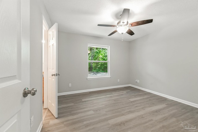 6257 Mohawk Trl, Milton, FL 32583 - unfurnished room with a ceiling fan, light wood-style flooring, baseboards, and a textured ceiling