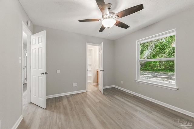 6257 Mohawk Trl, Milton, FL 32583 - unfurnished bedroom with light wood-style floors, baseboards, a ceiling fan, and ensuite bathroom