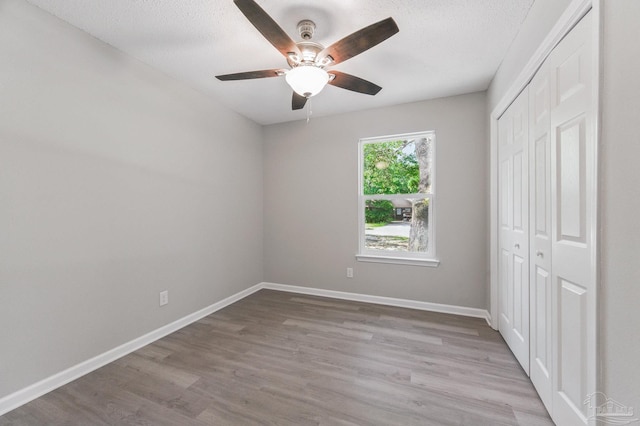 6257 Mohawk Trl, Milton, FL 32583 - unfurnished bedroom with a closet, wood finished floors, baseboards, a ceiling fan, and a textured ceiling