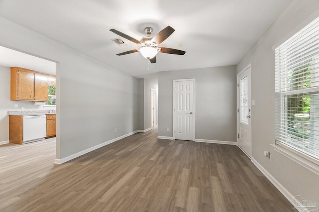 6257 Mohawk Trl, Milton, FL 32583 - unfurnished living room with light wood-style floors, healthy amount of natural light, a ceiling fan, and baseboards
