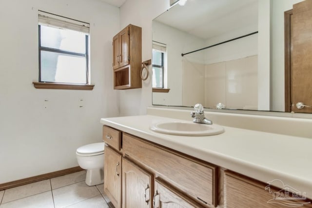 bathroom featuring a healthy amount of sunlight, vanity, toilet, and tile patterned floors