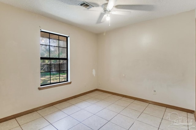 unfurnished room featuring light tile patterned floors, visible vents, a ceiling fan, a textured ceiling, and baseboards