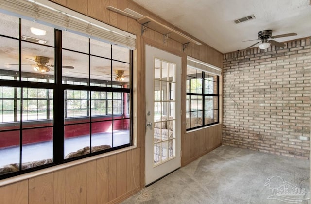 unfurnished sunroom with ceiling fan and visible vents