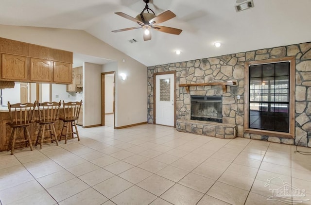 living area featuring light tile patterned flooring, a fireplace, and visible vents