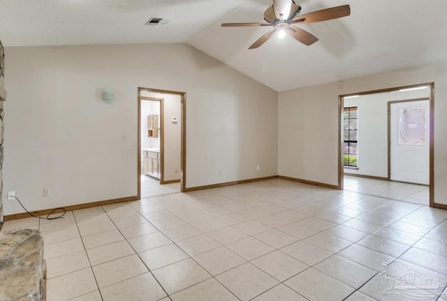 spare room with light tile patterned floors, baseboards, visible vents, a ceiling fan, and vaulted ceiling