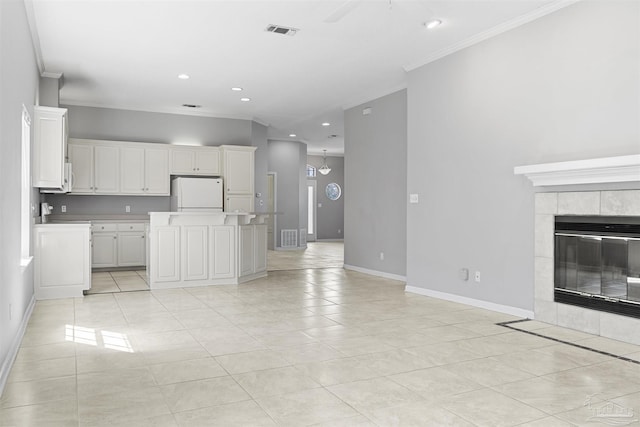 kitchen featuring freestanding refrigerator, light countertops, visible vents, and white cabinetry