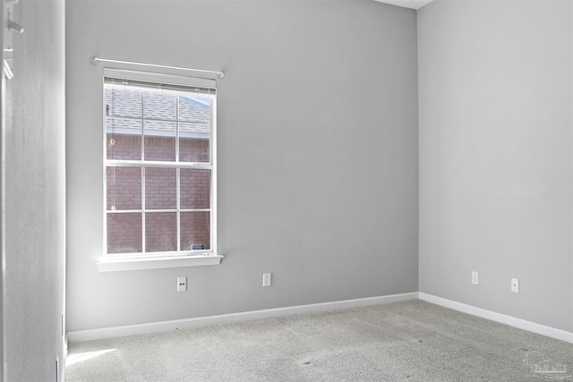 unfurnished room with light carpet and baseboards