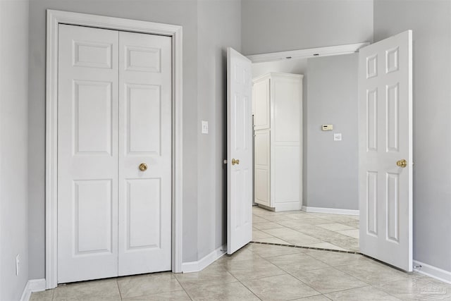 unfurnished bedroom with baseboards and light tile patterned floors