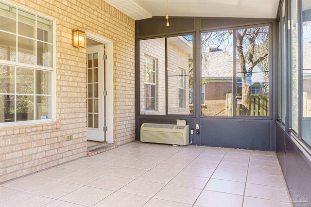 unfurnished sunroom featuring vaulted ceiling and a wall mounted AC