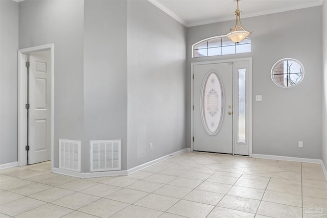 entryway with light tile patterned floors, baseboards, visible vents, and crown molding