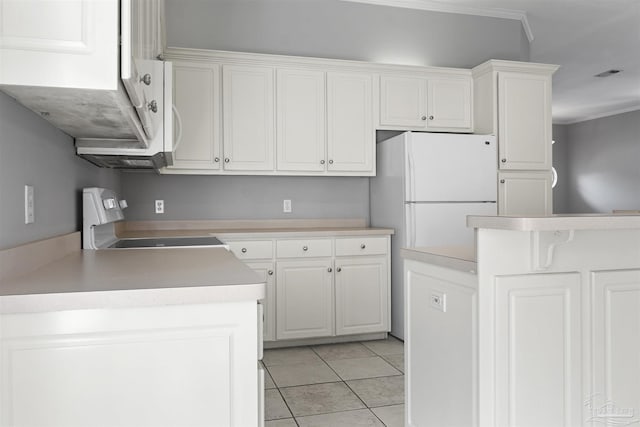 kitchen featuring light tile patterned floors, stove, visible vents, white cabinets, and freestanding refrigerator