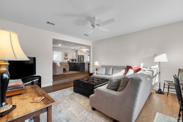 living room with ceiling fan and light hardwood / wood-style floors