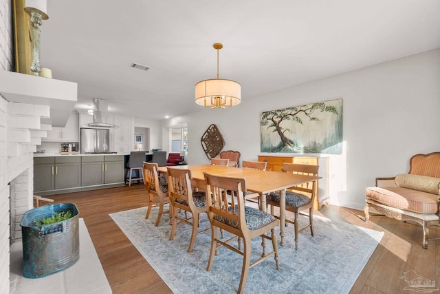 dining room featuring a fireplace and light hardwood / wood-style flooring