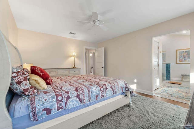 bedroom featuring ceiling fan, wood-type flooring, and ensuite bathroom