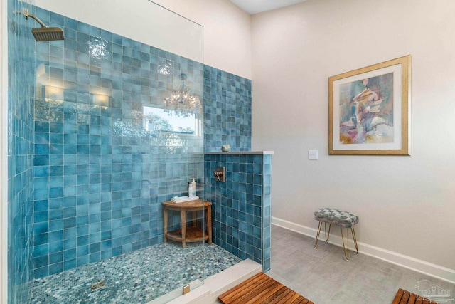 bathroom with a chandelier and a tile shower