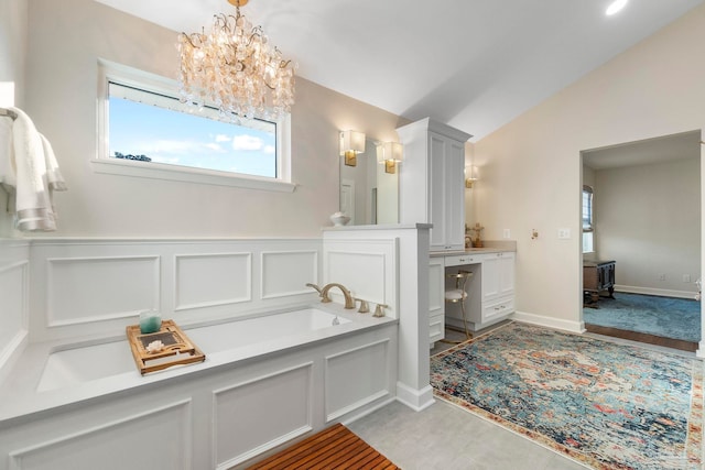 bathroom featuring a tub, plenty of natural light, a notable chandelier, and vaulted ceiling