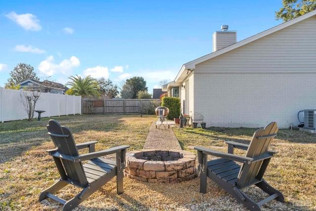 view of yard featuring central AC and an outdoor fire pit