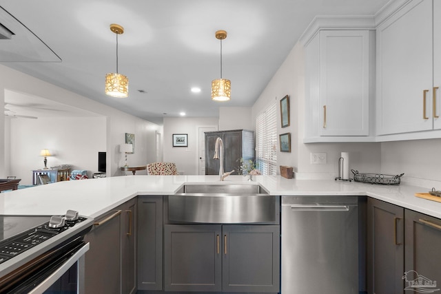 kitchen with pendant lighting, white cabinetry, stainless steel appliances, sink, and ceiling fan