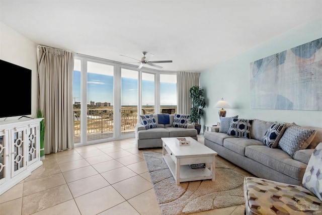 living room with a water view, expansive windows, ceiling fan, and light tile patterned flooring