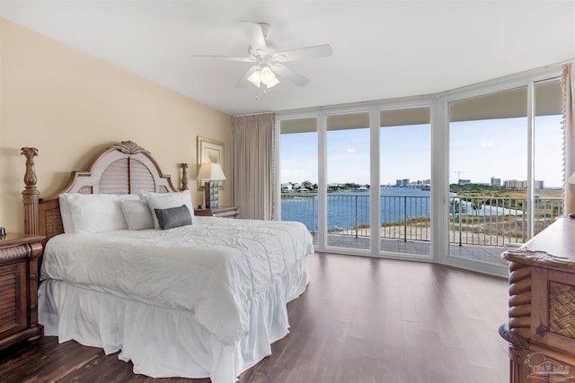 bedroom featuring access to exterior, ceiling fan, dark hardwood / wood-style floors, and a water view