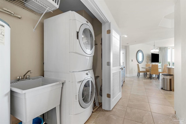 laundry room with stacked washer / dryer, sink, and light tile patterned floors