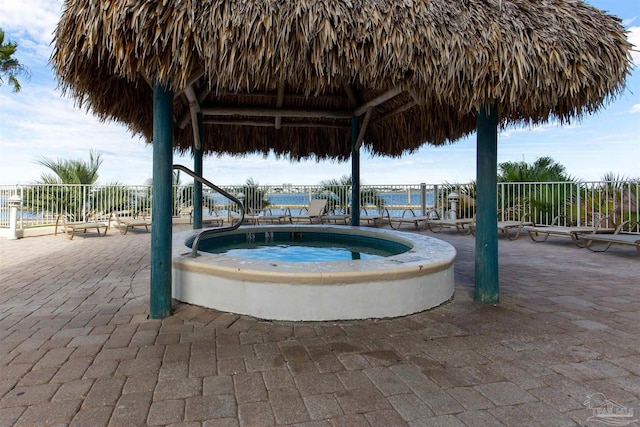 view of pool with a gazebo, an in ground hot tub, a water view, and a patio