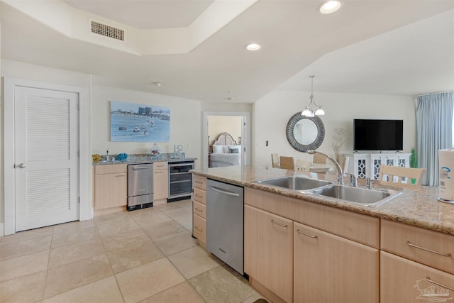 kitchen featuring sink, light brown cabinets, dishwasher, wine cooler, and hanging light fixtures