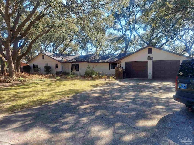 ranch-style home with a garage and a front lawn