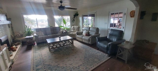 living room featuring a brick fireplace and ceiling fan