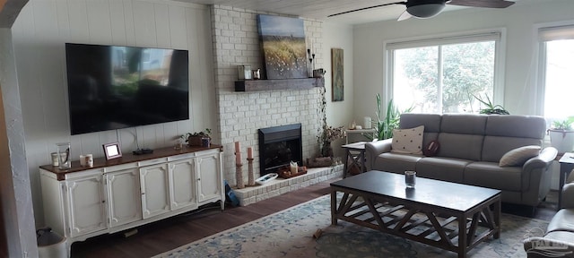 living room featuring ceiling fan, a fireplace, and dark hardwood / wood-style floors