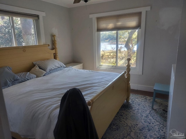 bedroom with multiple windows, hardwood / wood-style flooring, and ornamental molding